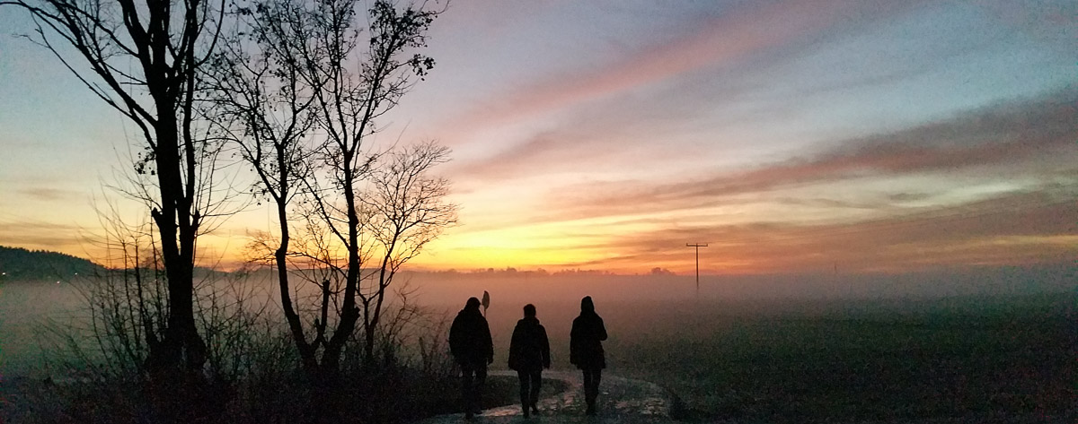 Drei Personen gehen in die herbstliche Abendsonne 